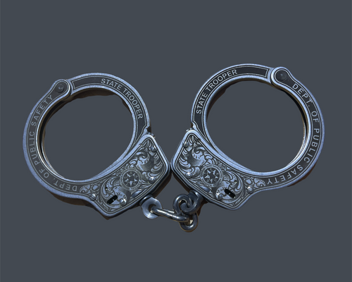 Pair of silver handcuffs on a gray background with 'PhotoRoom' branding.
